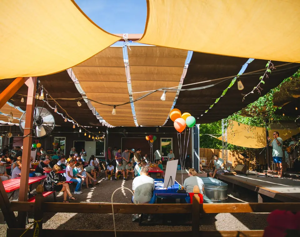 A crowd gathered under shade sails for an outdoor service